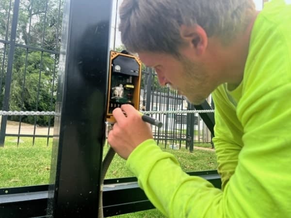 Electric gate technician performing diagnostics on an automatic gate in Oklahoma City, Oklahoma.