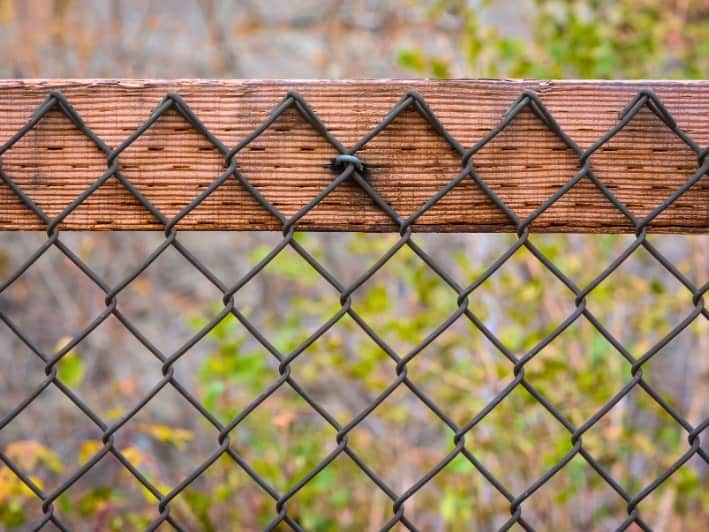 How chain link fence is combined to a wood fence.